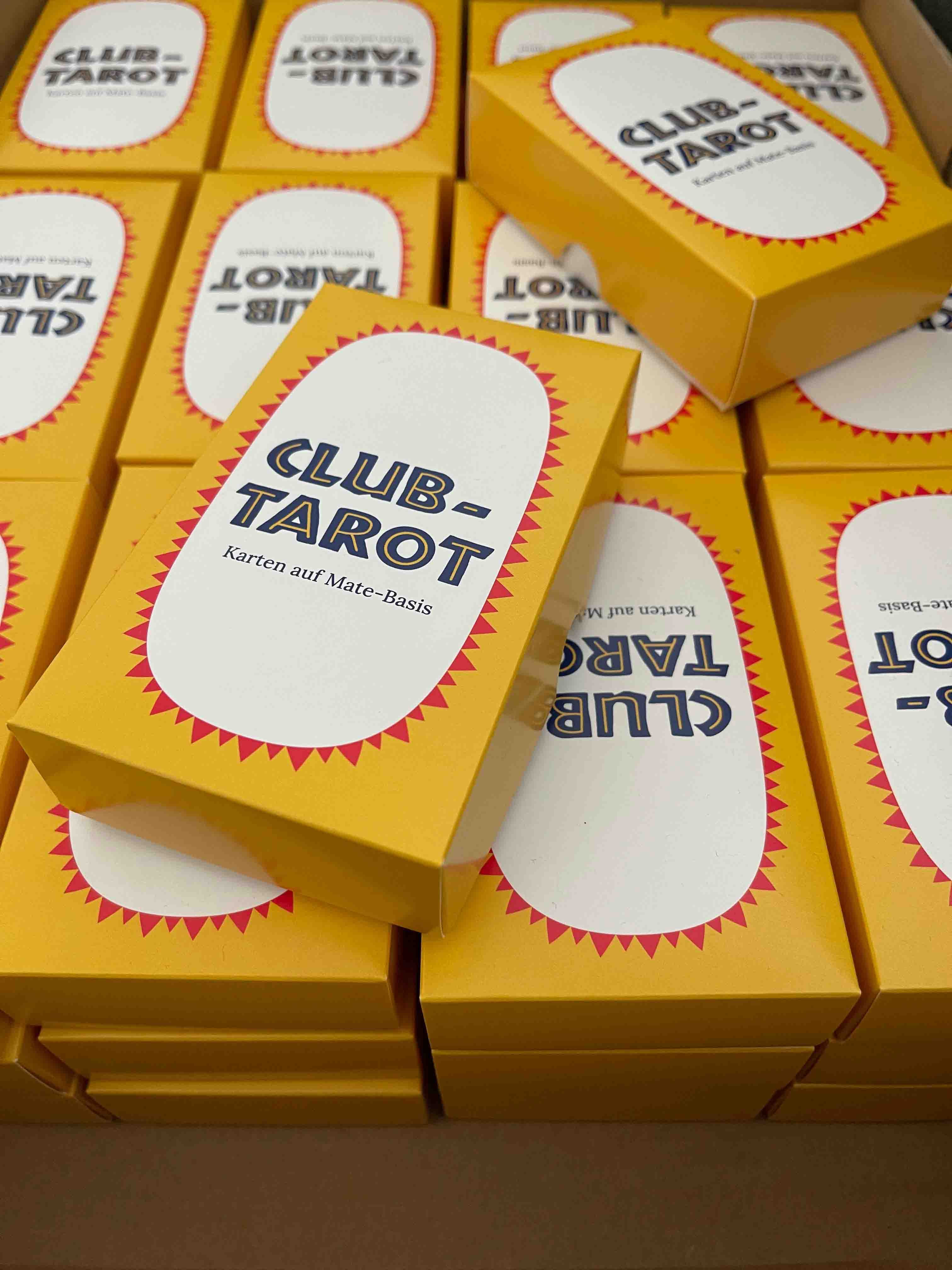 Stacks of Club Tarot decks in a cardboard box.