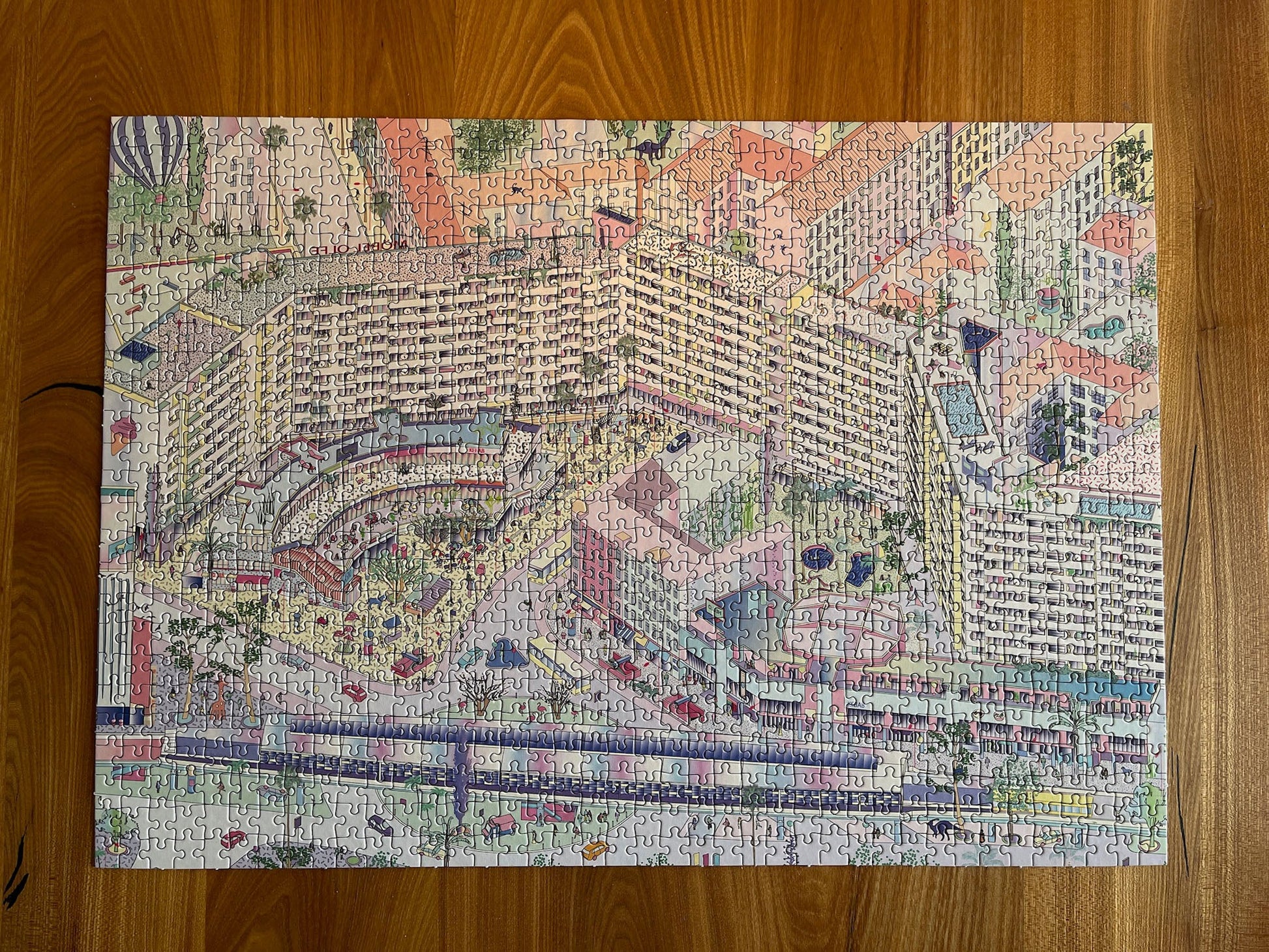 Completed Berlin jigsaw puzzle of illustrated Kottbusser Tor, Kreuzberg, on wooden table.