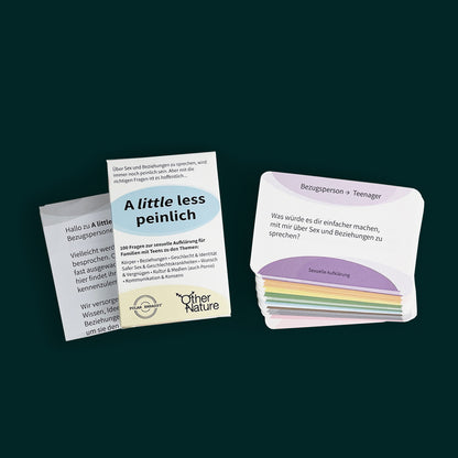 Against a dark green background is a deck of question cards, in white with rainbow details. There is a stack of cards, an instruction sheet, and a box titled "A Little Less Peinlich".