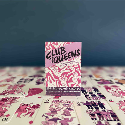 Pink and purple box of playing cards on top of the cards, in front of a dark blue background.