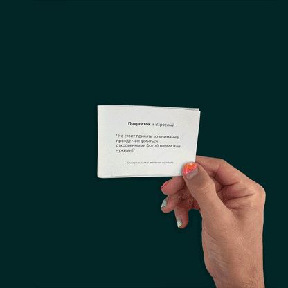 Hands with bright nail polish hold colorful cards with sex education questions in English, German, and Russian.