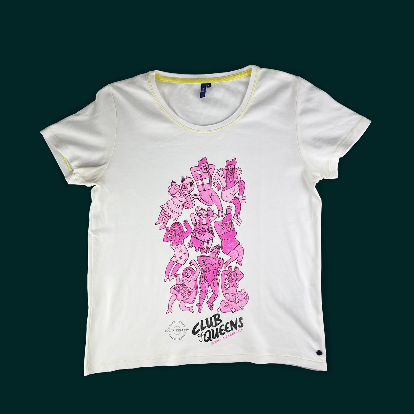 Club of Queens drag queen motif on a white shirt: nine pink drag queens and kings are hand-screen printed on a large white shirt on a dark green background. The Polar Embassy logo and "Club of Queens, Rory Midhani 2024" are below the graphic.