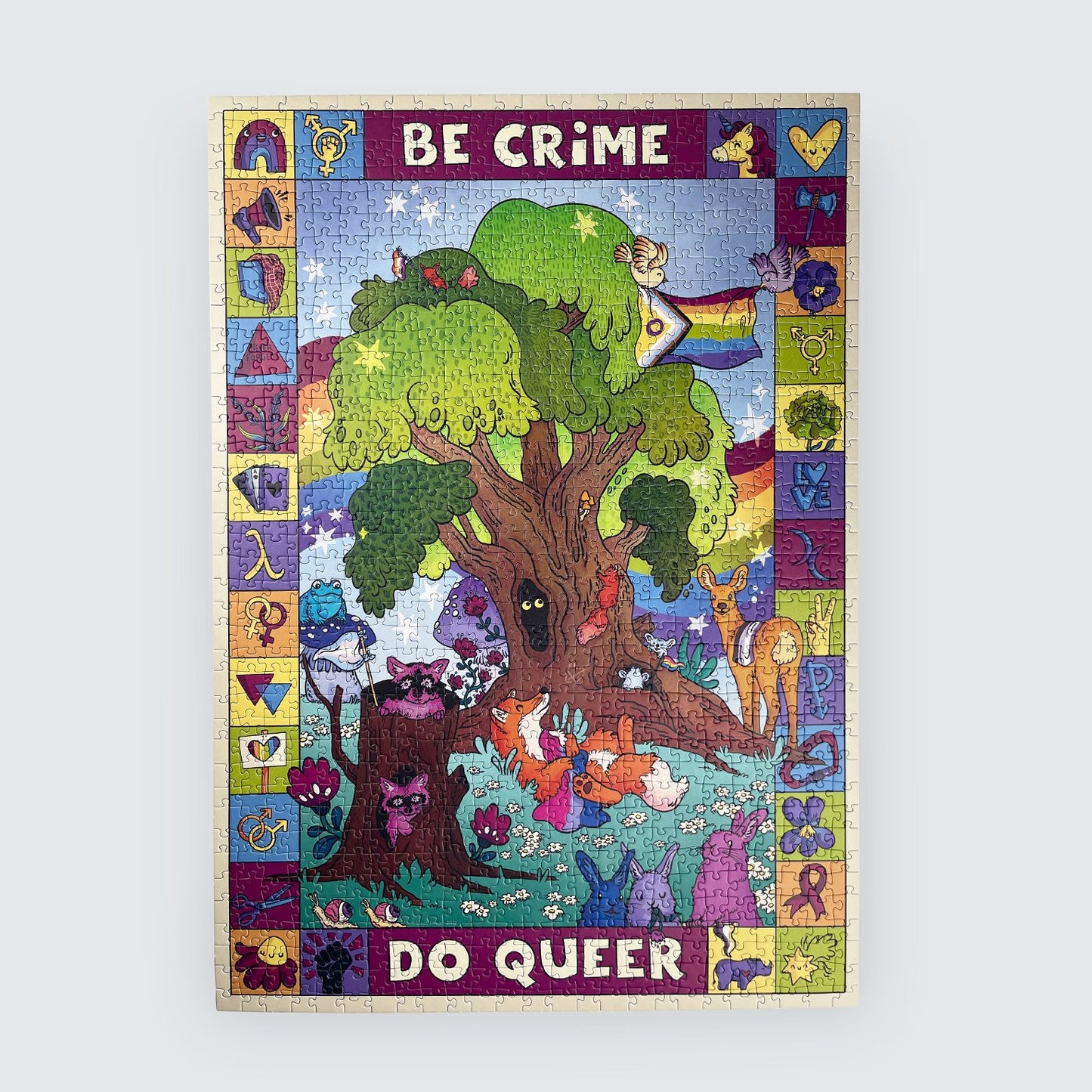Colorful jigsaw puzzle with a tree and animals, featuring text 'Be Crime Do Queer' on a light gray background.