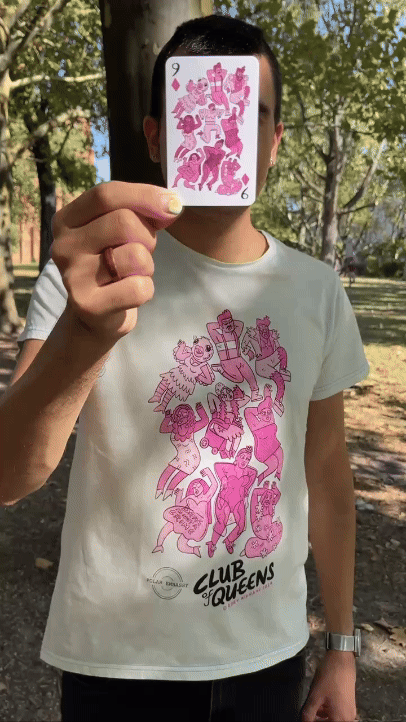 GIF of a person in a sunny park holding a nine of diamonds playing card, with pink drag queens. The same graphic is on the shirt (with one character replaced with a queen in a wheelchair). The person's face is hidden from view by the card, and they bring the card closer to view.