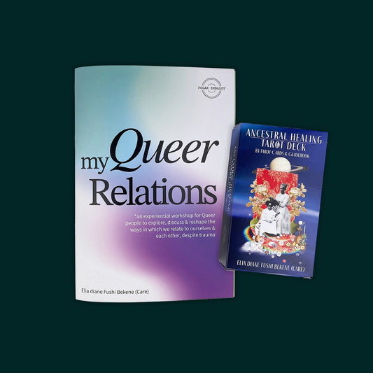 A workbook and tarot deck lay on a dark green background.