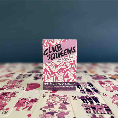 Pink and purple box of playing cards on top of the cards, in front of a dark blue background.