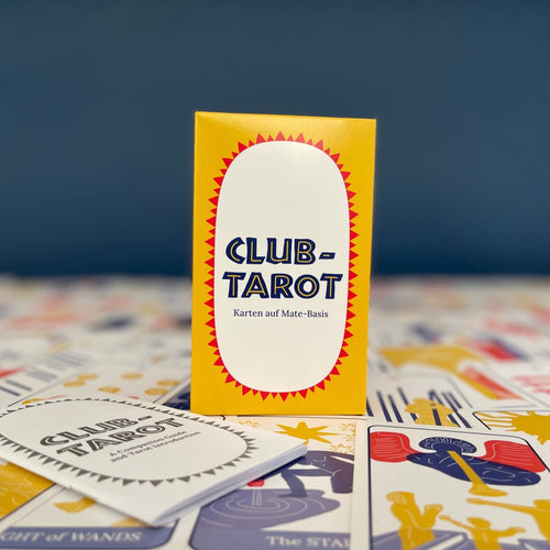 Modern tarot deck for beginners laid out with colorful box and guidebook on a dark blue background.
