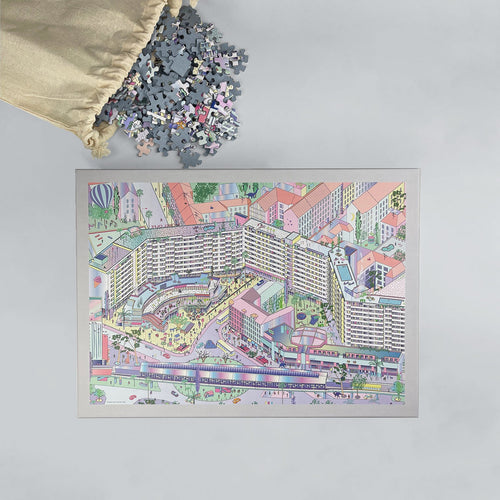 Berlin jigsaw puzzle of colorful Kottbusser Tor, pieces spilling from cotton bag beside box.