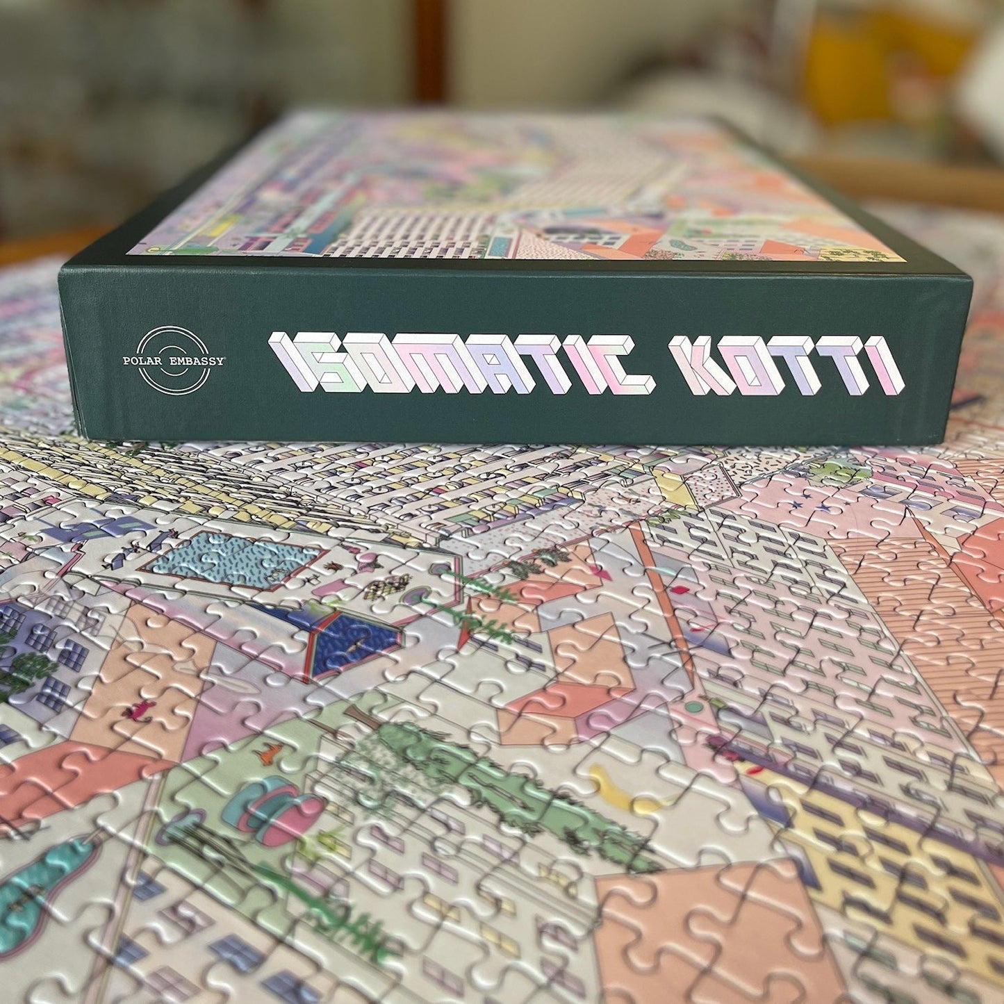 A puzzle box with the Polar Embassy logo and the title "ISOMATIC KOTTI" lays on the completed puzzle