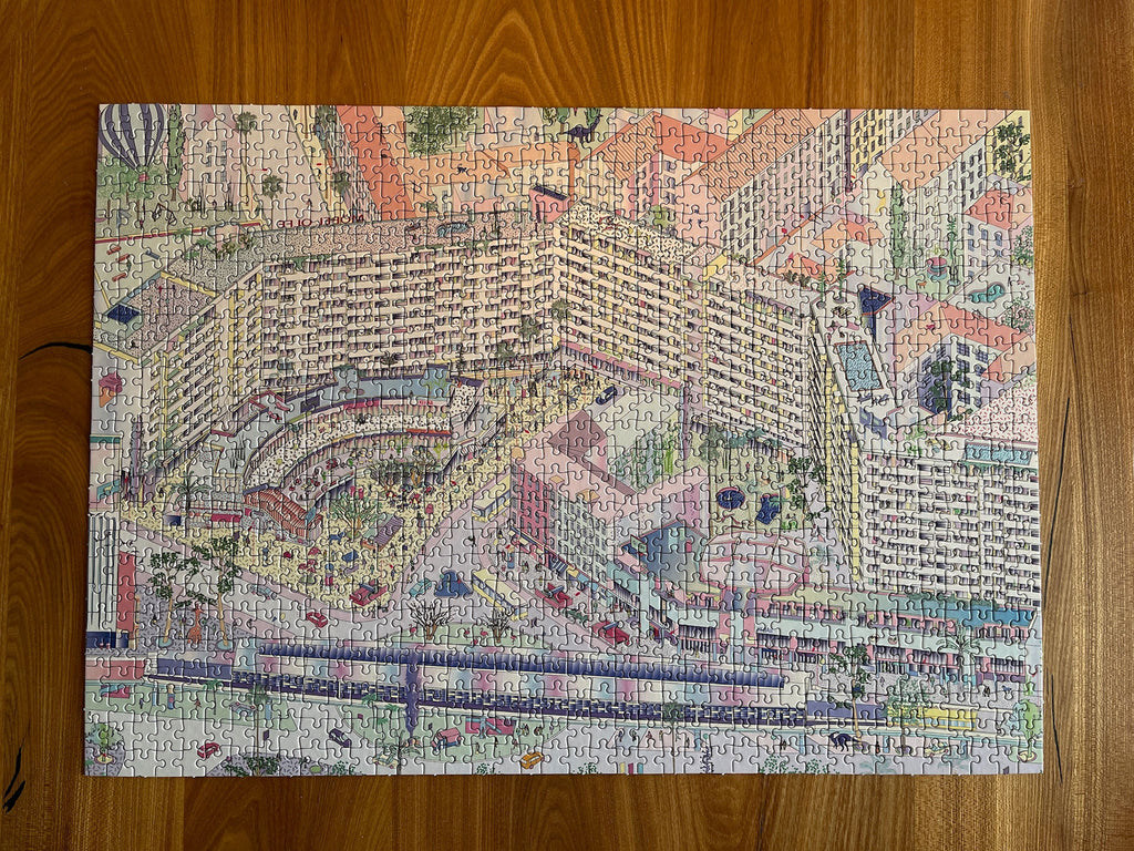 Completed Berlin jigsaw puzzle of illustrated Kottbusser Tor, Kreuzberg, on wooden table.