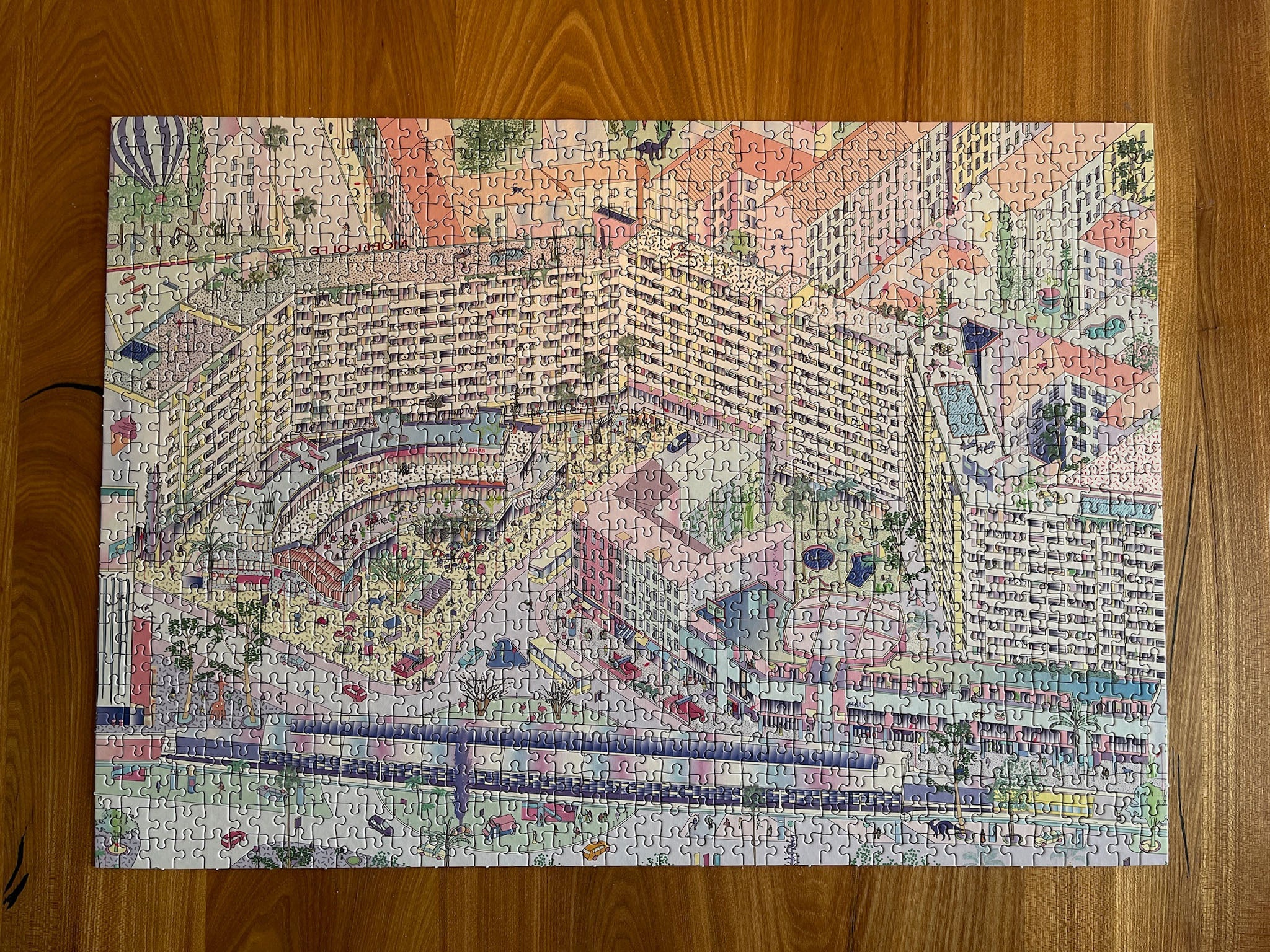 Completed Berlin jigsaw puzzle of illustrated Kottbusser Tor, Kreuzberg, on wooden table.
