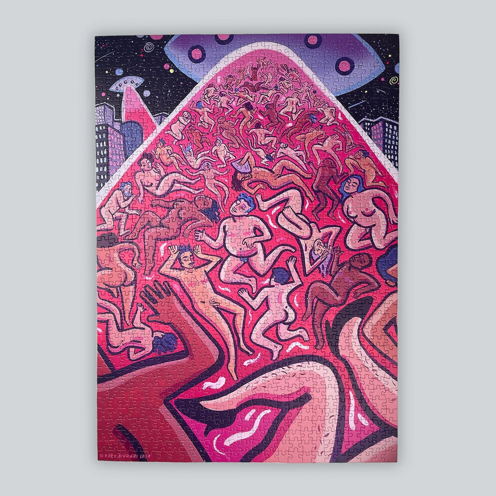 A completed rectangular art puzzle featuring a stylized, colorful illustration of many nude trans* and queer human figures being light-beamed up by a flying saucer in a dark starry sky above, shown against a light gray background.