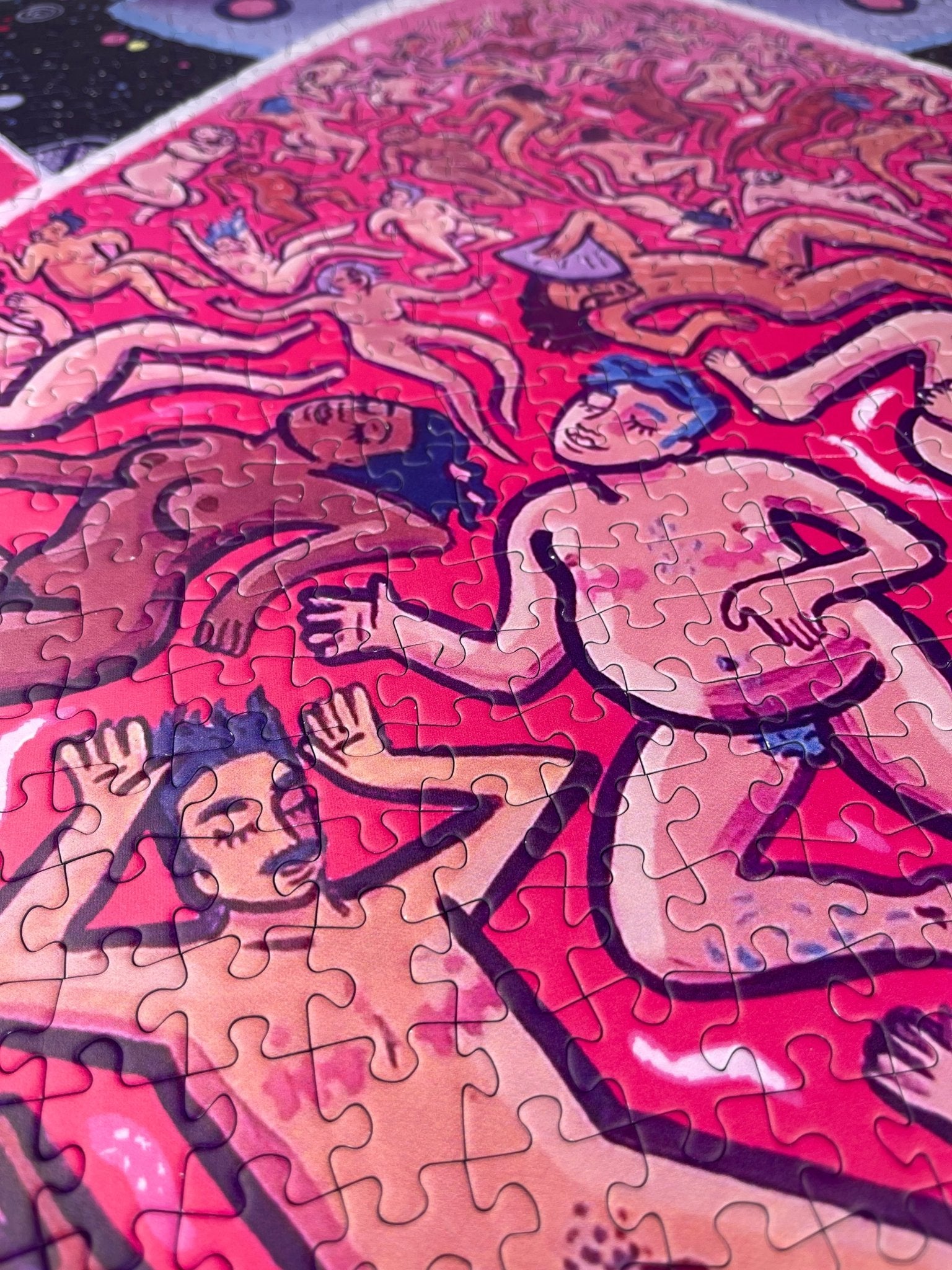 A close-up of a completed jigsaw puzzle showing a stylized, psychedelic illustration of figures in pink, red, peach, and purple tones.