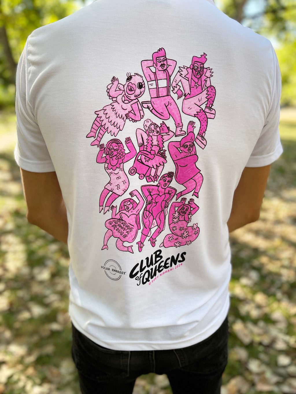 Back view of Club of Queens upcycled t-shirt with pink drag queen artwork in a Berlin park.