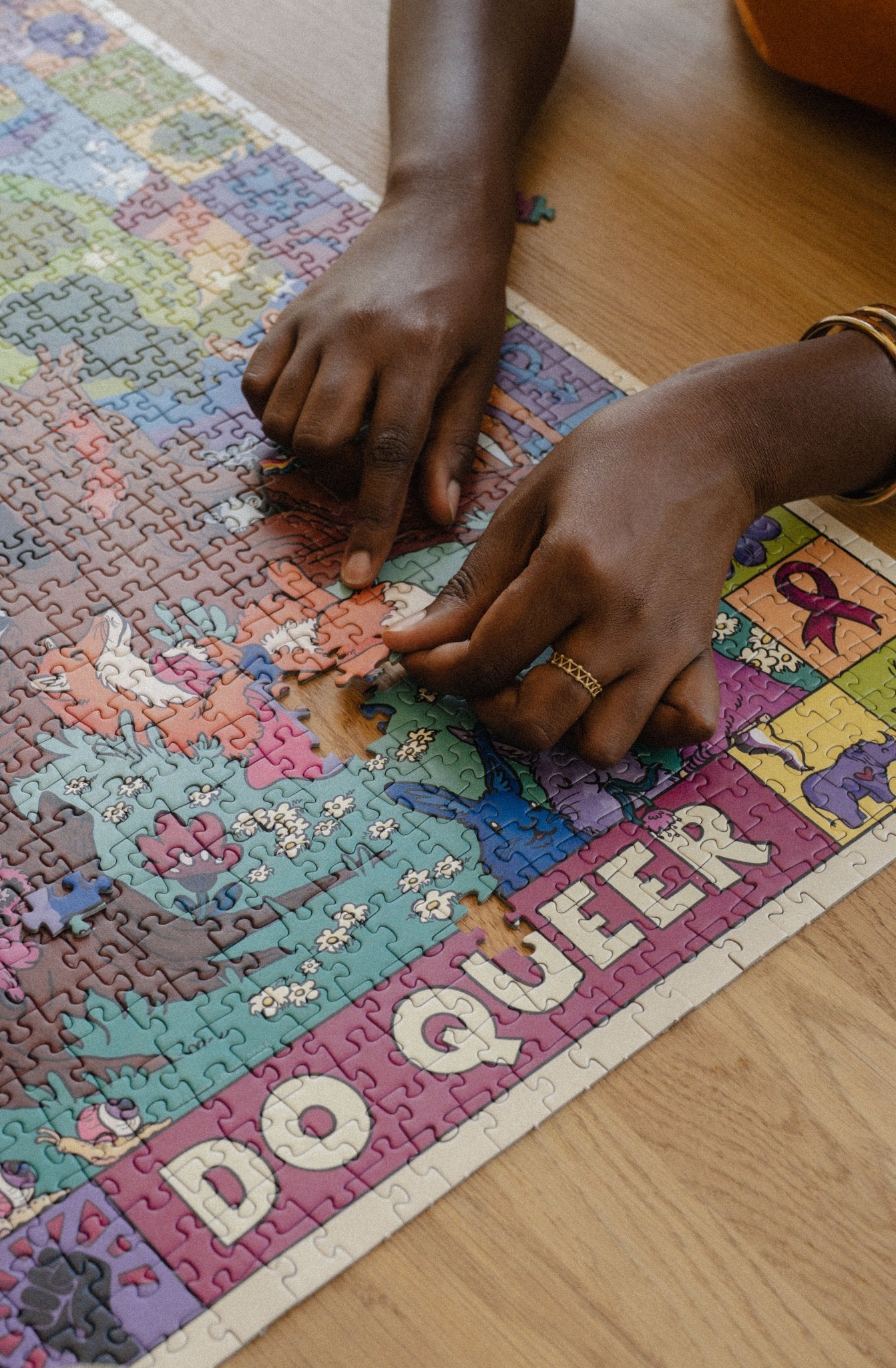 Close-up of the last piece going into Louie Läuger's Be Crime, Do Queer queer jigsaw puzzle.