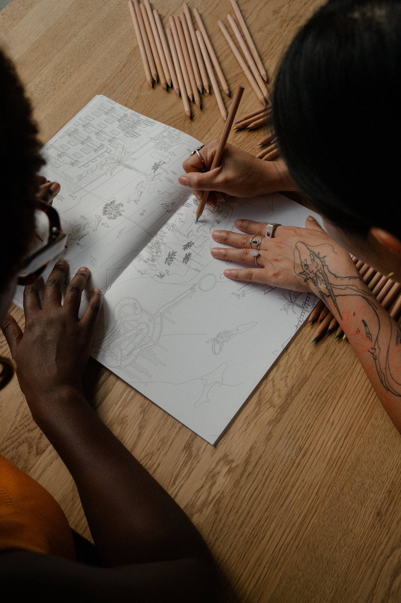Hands colouring a page of the Berlin Coloring Book for adults, Isomatic art by Bruno Pinto da Cruz.
