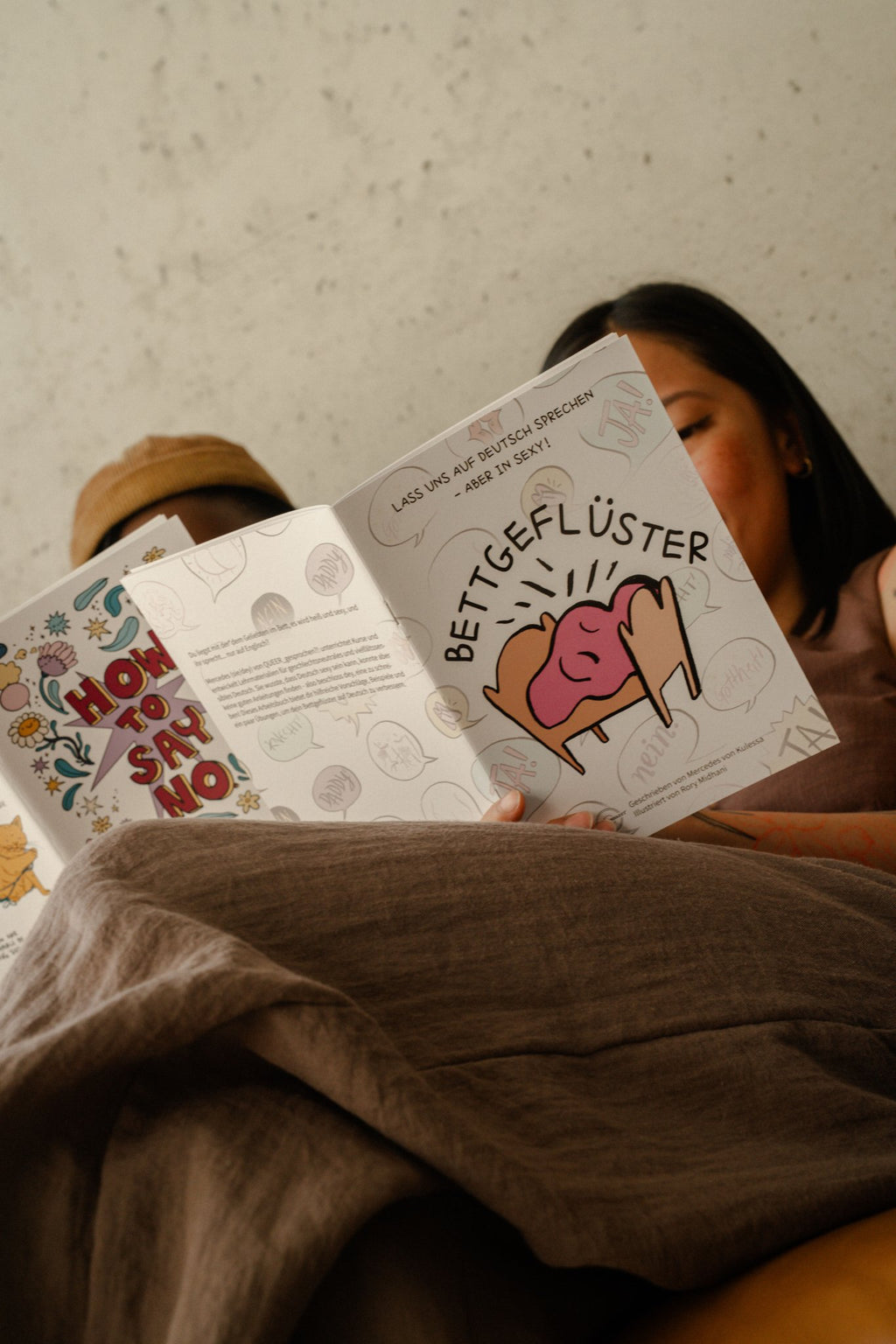 Person liest Bettgeflüster - Dirty Talk auf Deutsch, das Paar-Workbook von Polar Embassy.
